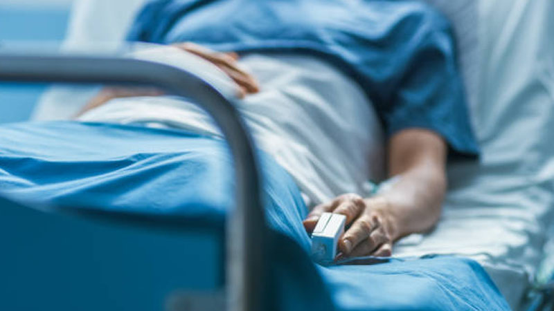 A woman lies in coma in a hospital bed